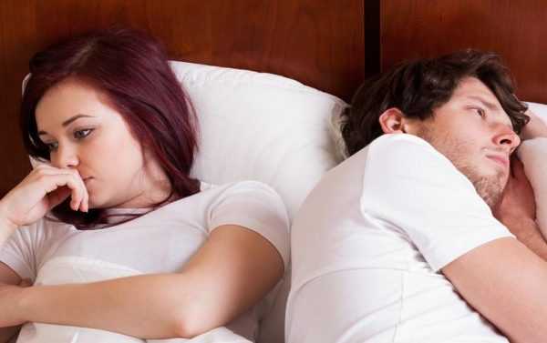Мужчина и женщина лежат в постели, отвернувшись друг от друга