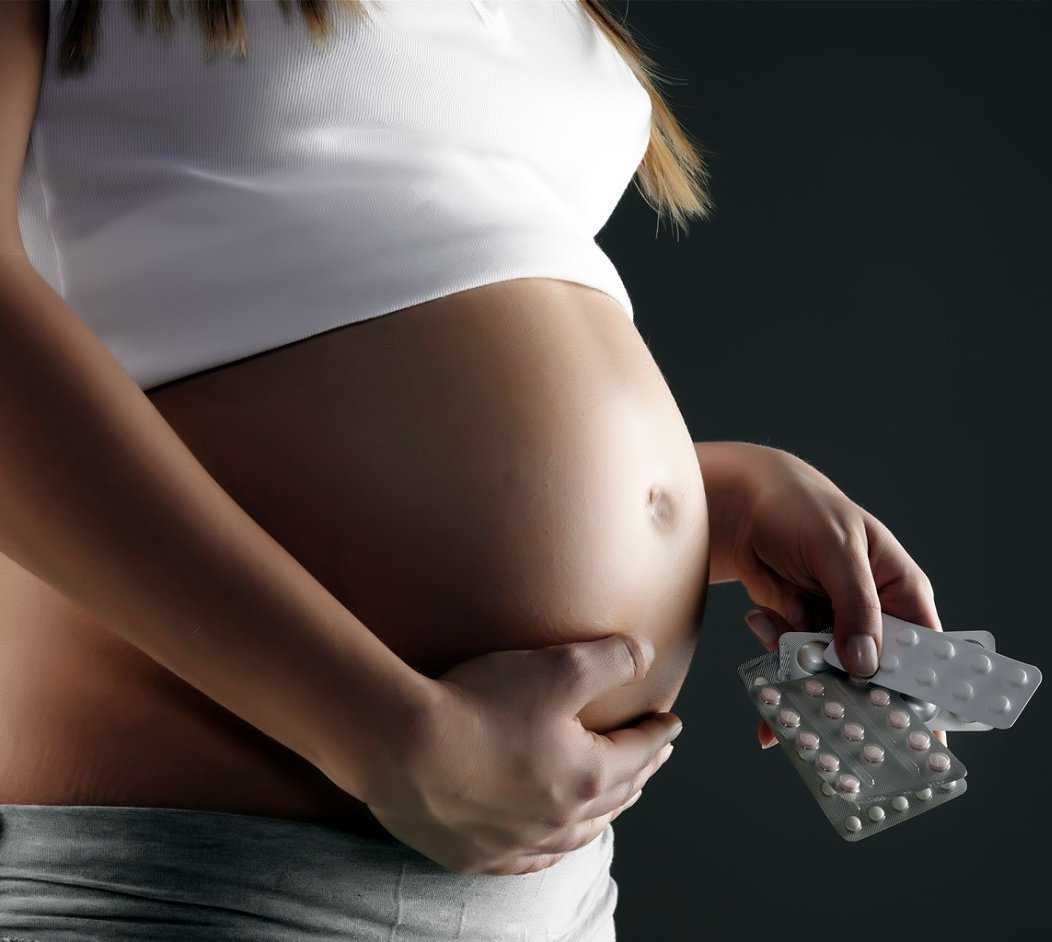 Беременная держит таблетки