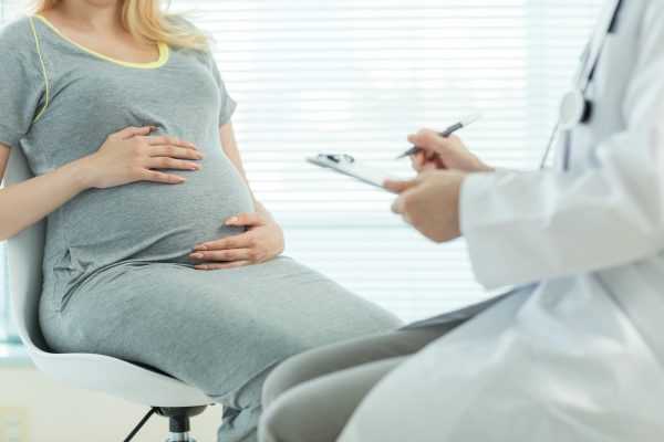 врач пальпирует живот беременной