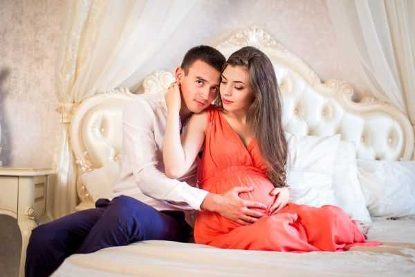 Беременная женщина с мужем в постели