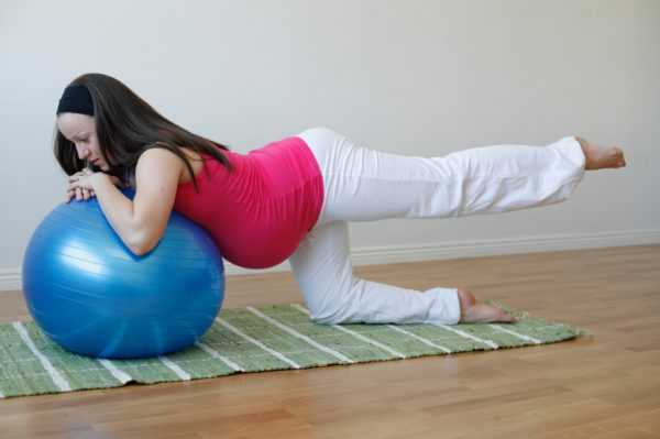 Беременная тренируется на фитболе