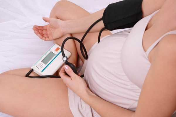 Беременная женщина измеряет давление