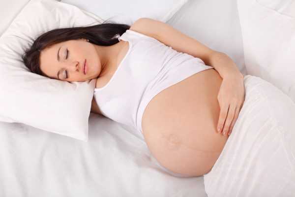 Беременная женщина спит в кровати