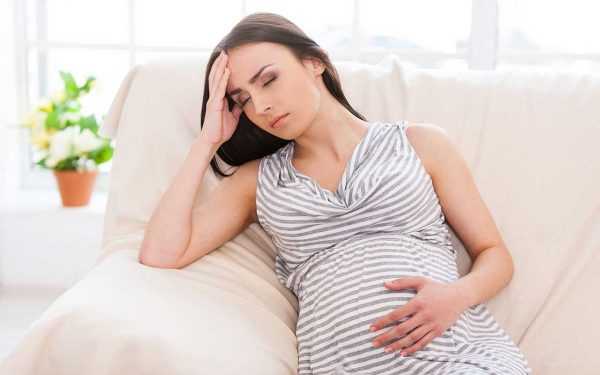 Беременная женщина отдыхает на диване