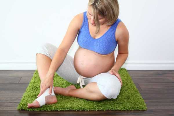 Беременная женщина смотрит на отёкшую ногу