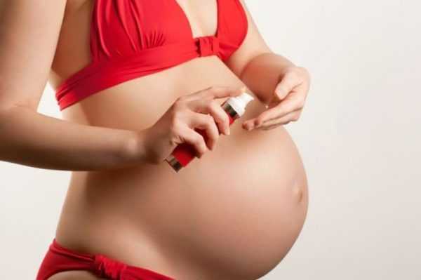 Беременная женщина выдавливает крем из тюбика
