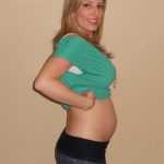 Девушка на 16-й неделе беременности показывает живот