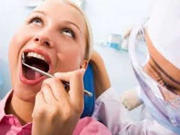 Врач-стоматолог оценивает состояние слизистой оболочки ротовой полости