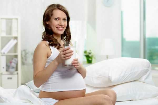 Беременная женщина со стаканом кефира