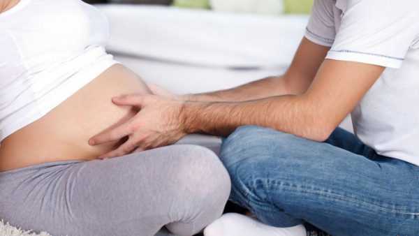 Муж трогает живот беременной жены