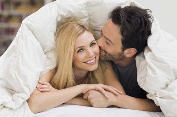 Парень целует девушку под одеялом