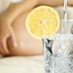 Беременная и стакан с водой и лимоном