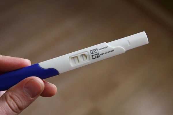 Положительный тест на беременность в руках