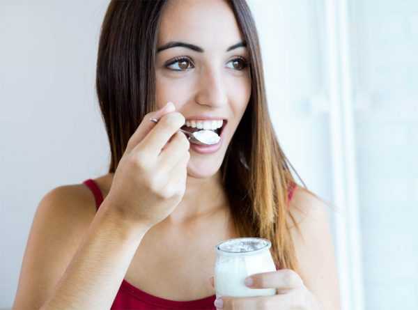 Девушка ест молочный продукт