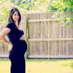 Будущая мама в 25 недель беременности на фоне забора