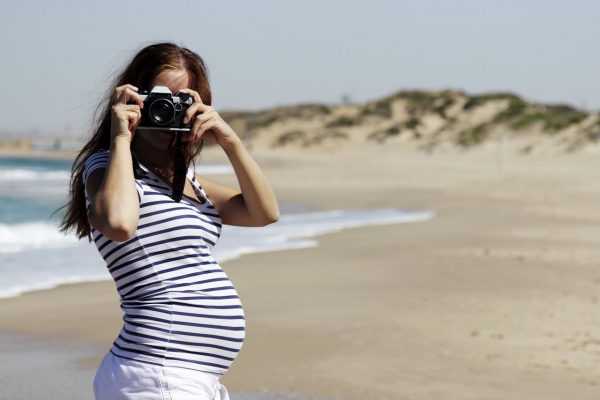 Беременная девушка фотографирует