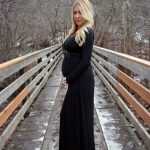 Девушка в чёрном платье на 22-й неделе беременности