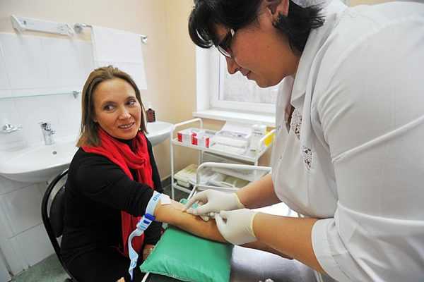 медсестра берёт кровь из вены у женщины
