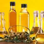 Оливковое масло в бутылках и оливки на столе