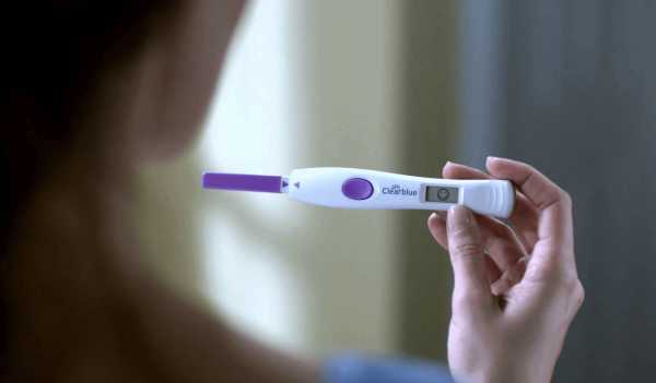 Девушка держит положительный тест на беременность