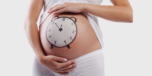 Беременная женщина с нарисованными на животе часами