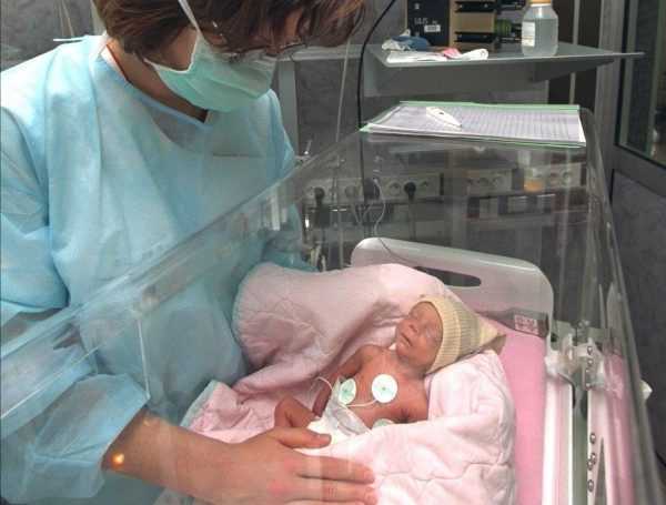 Новорождённый в кувезе и врач