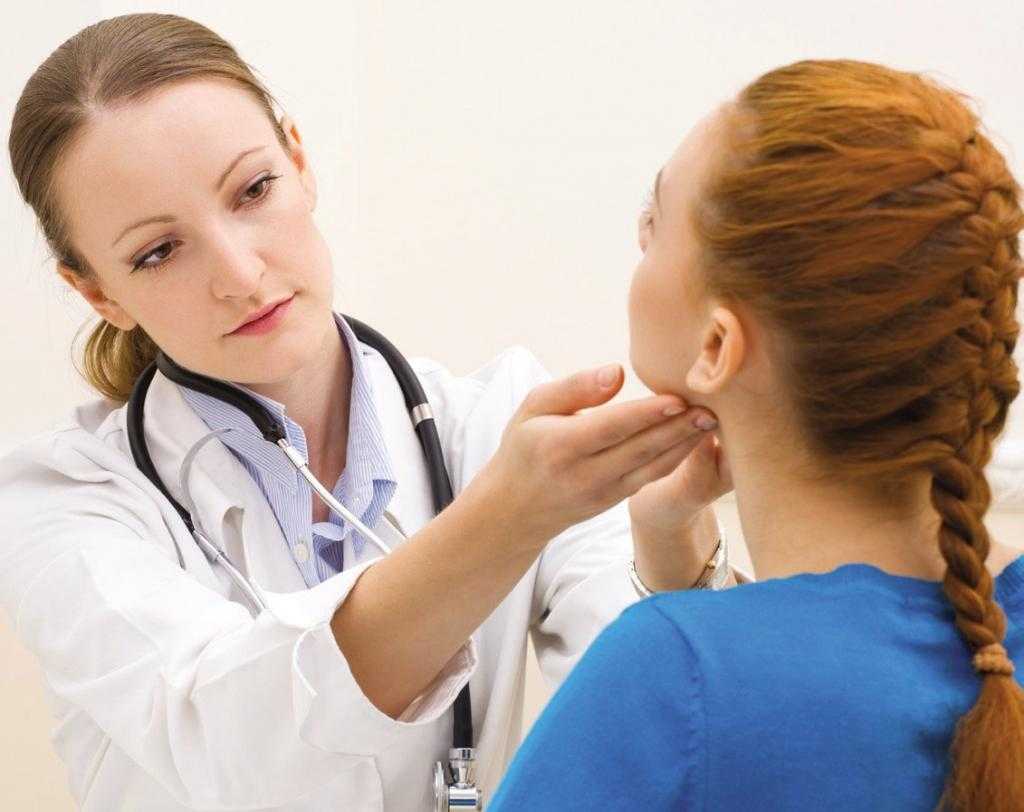 врач проверяет щитовидку у женщины